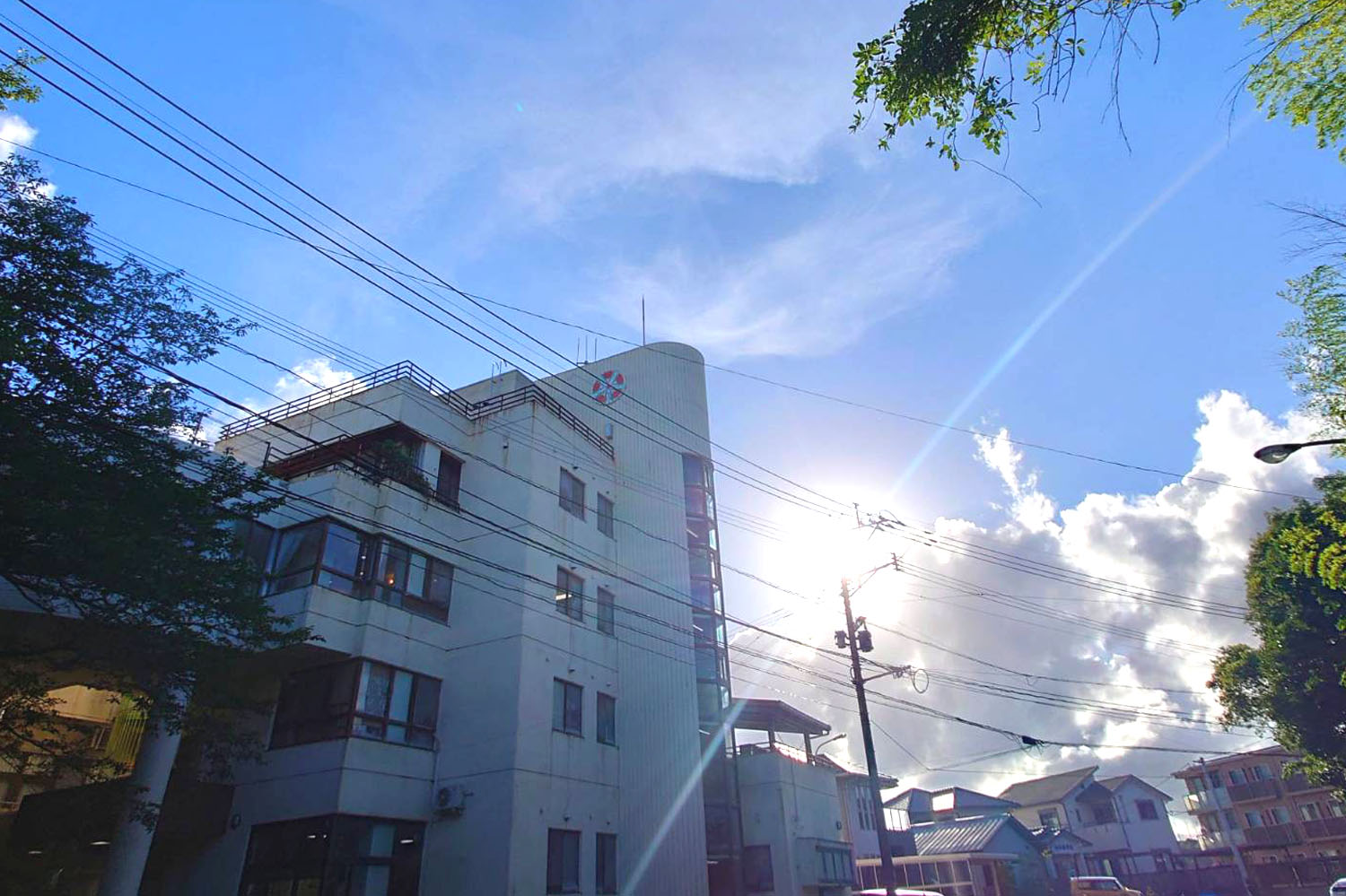 介護施設の外観。白い4階建て建物と周辺住宅地が見える。